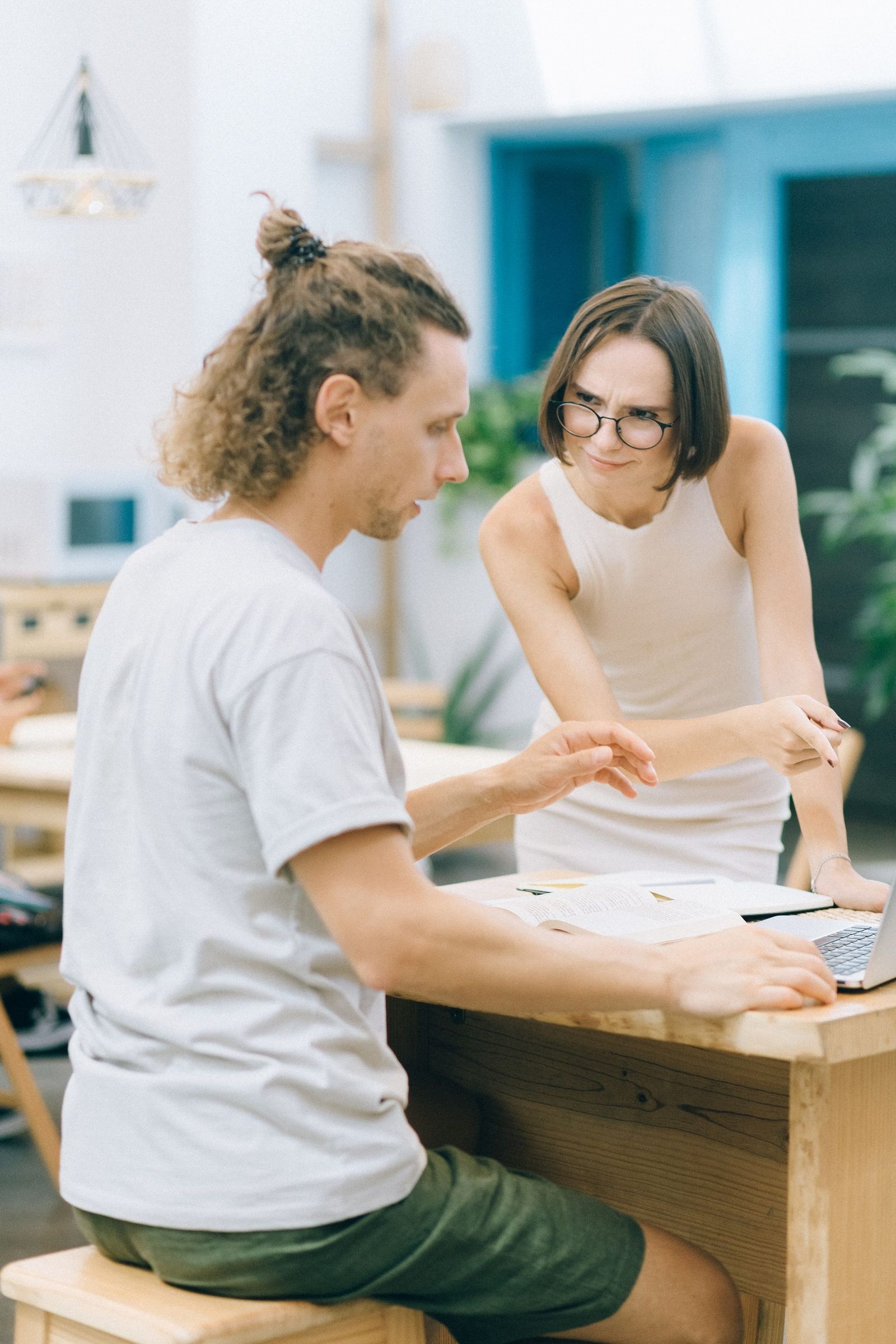 Zwei junge Leute besprechen Zahlen am Arbeitsplatz