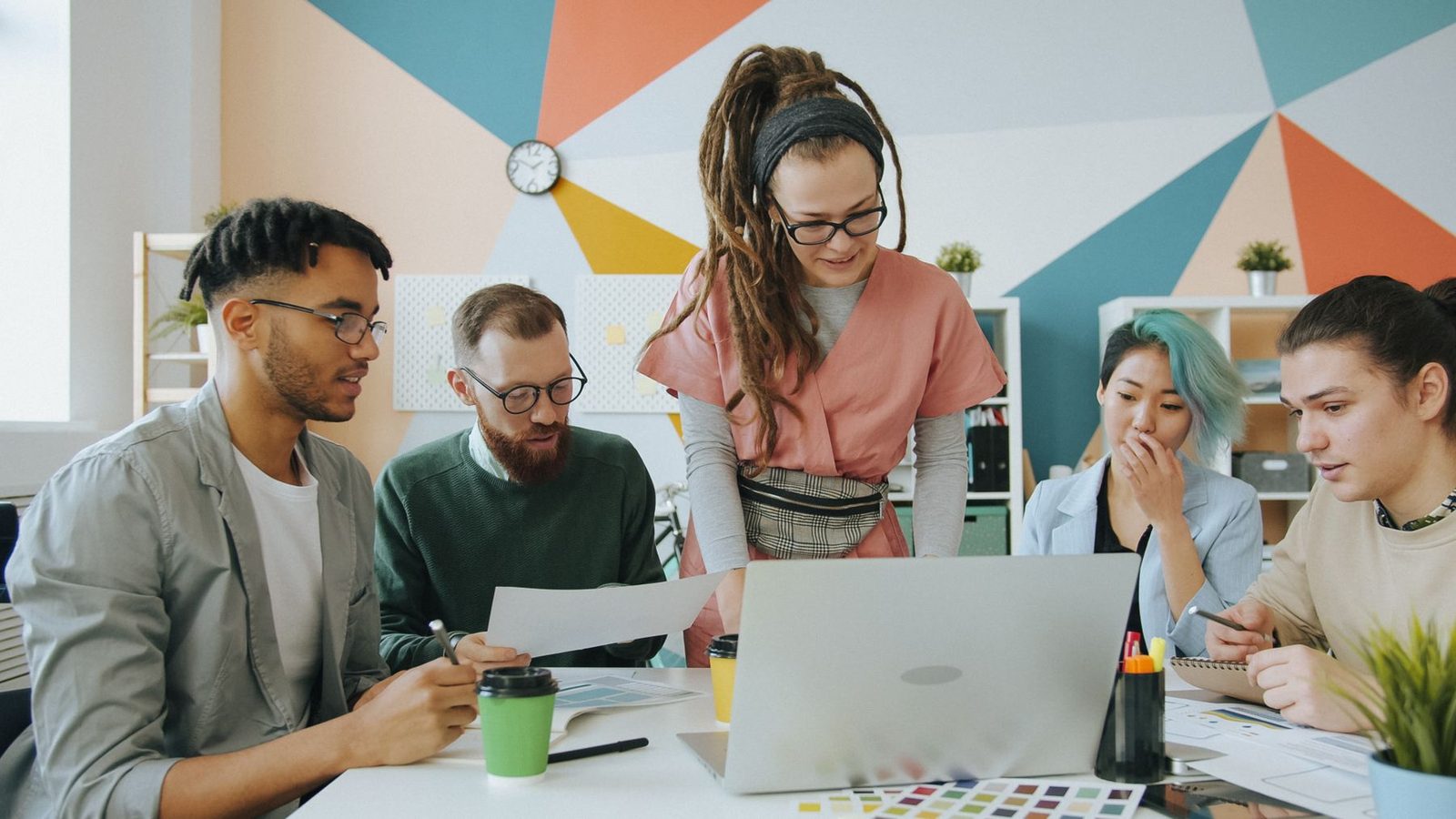 Junges Team arbeitet gemeinsam an Laptops